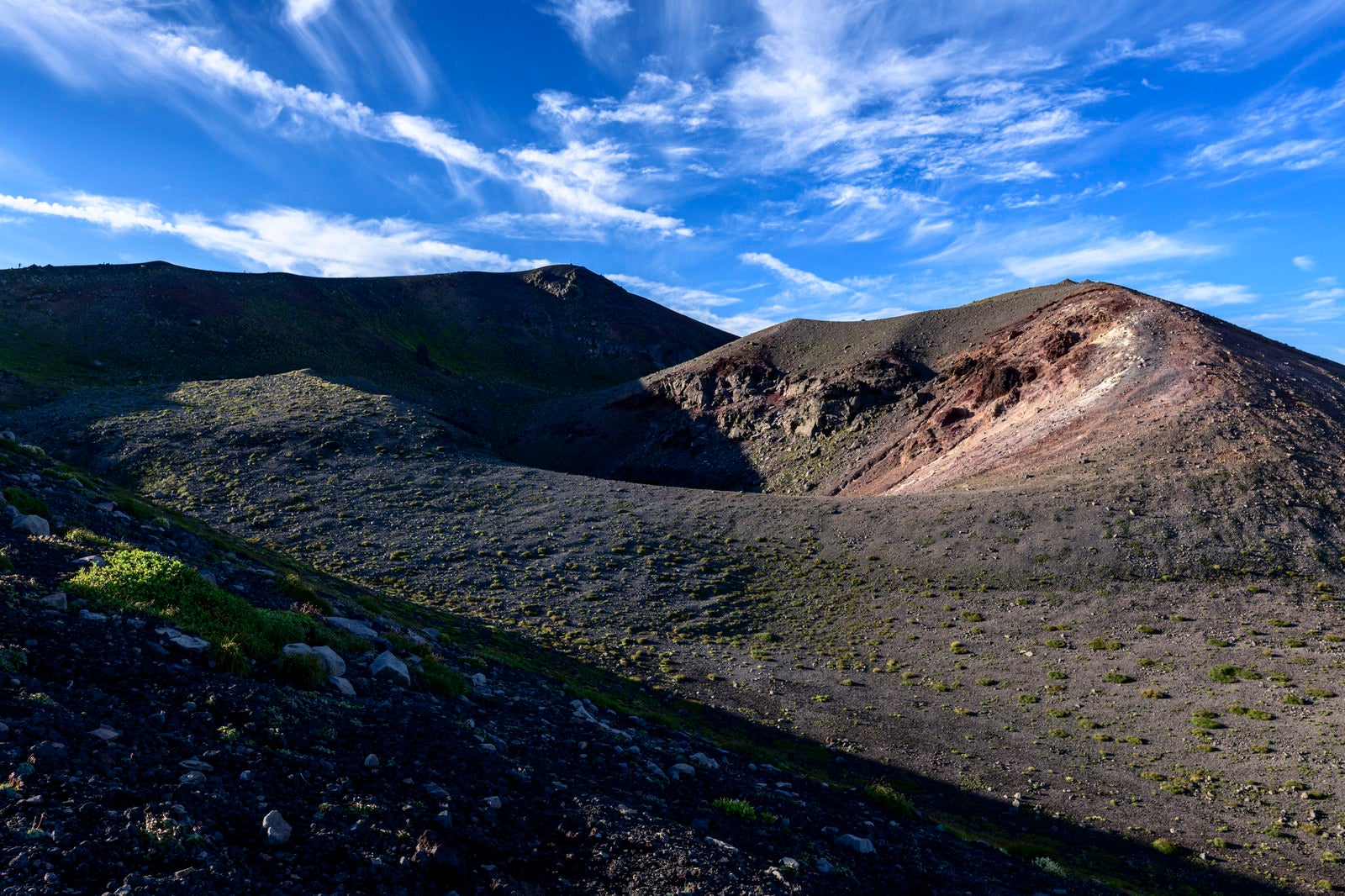 「西日で立体感のある景色を見せる岩手山山頂」の写真