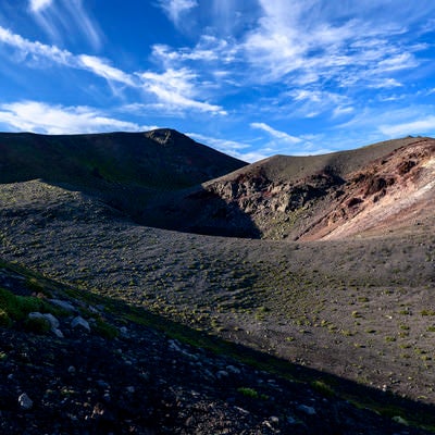 西日で立体感のある景色を見せる岩手山山頂の写真