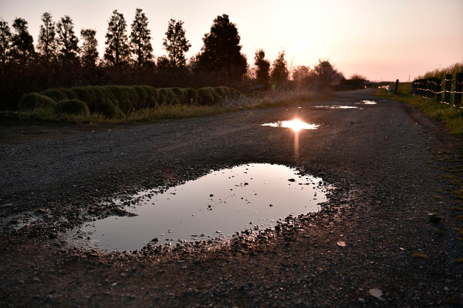 「朝日を反射する砂利の水たまり」の写真