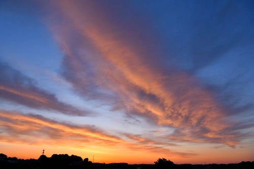 朝焼けに輝くオレンジの雲の写真