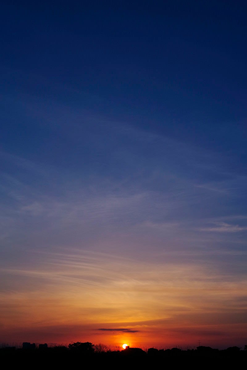 「深く青い空と夕日」の写真