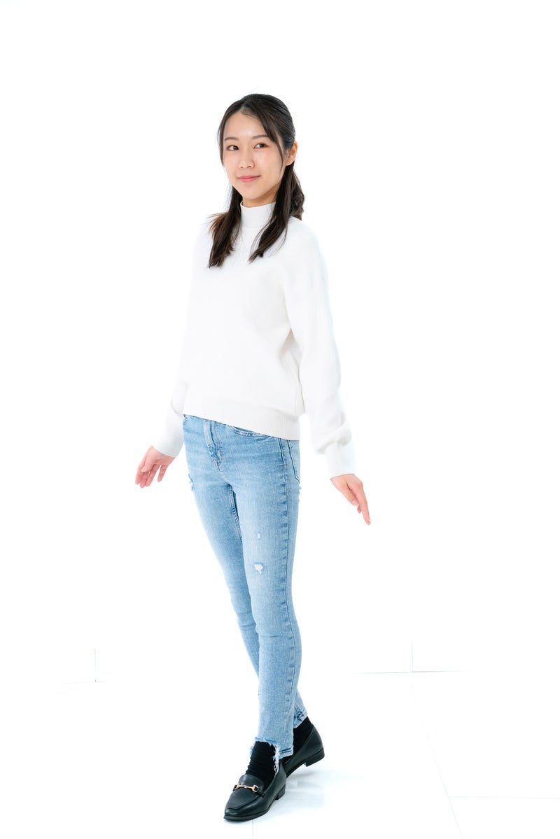 「白いトップスを試着する女性」の写真［モデル：SAKI］