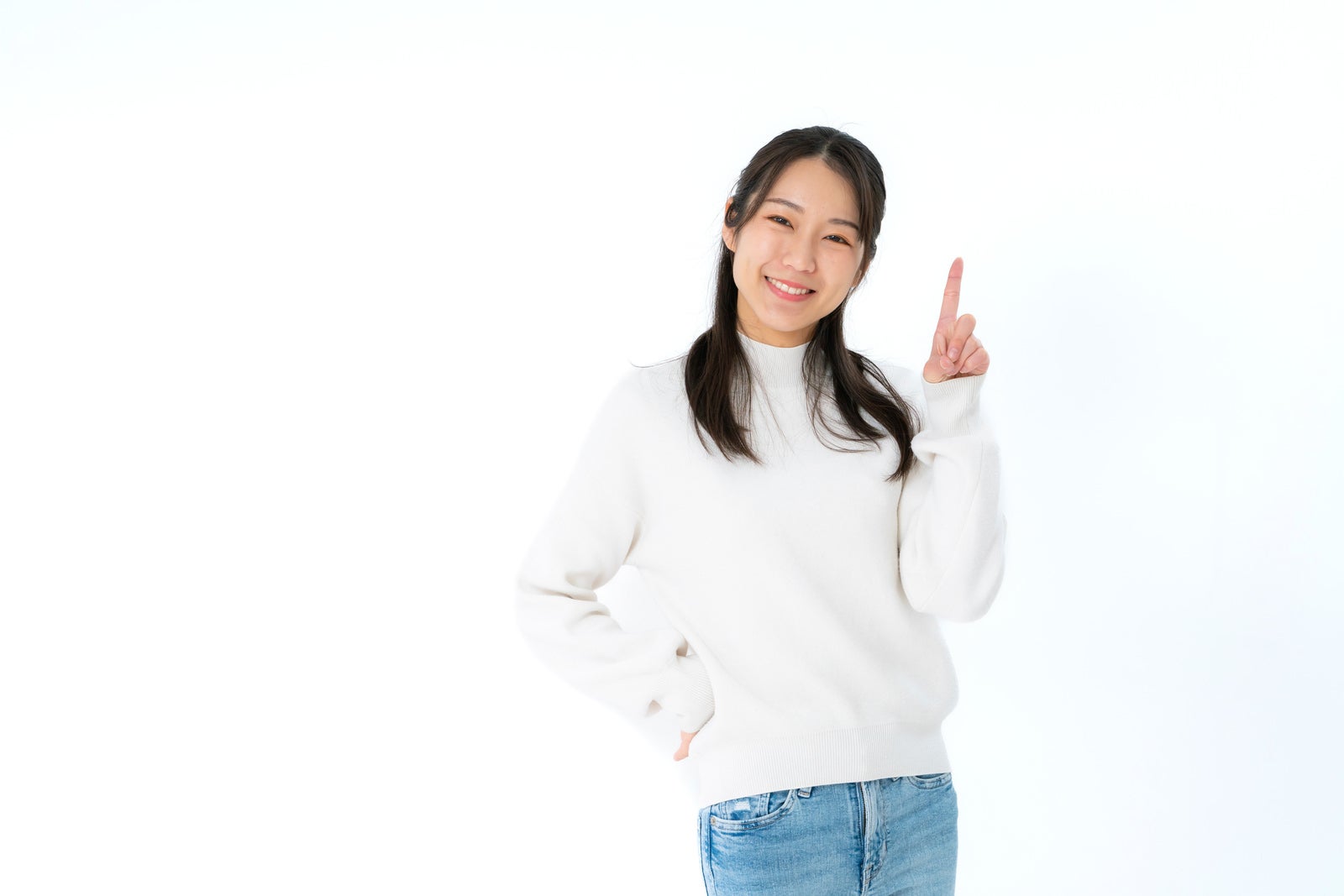 「人差し指を挙げて微笑みかける女性」の写真［モデル：SAKI］