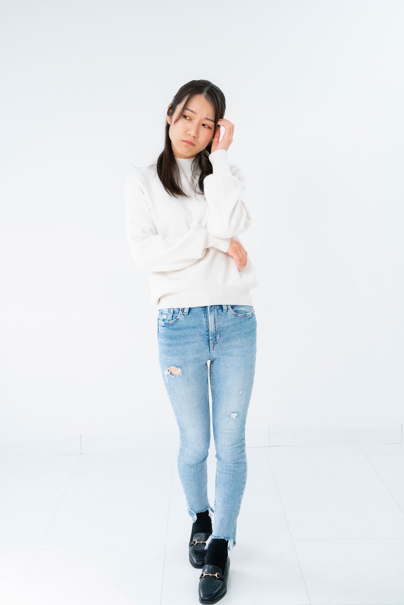 立ち上がって悩む女性 photo [Model: SAKI]