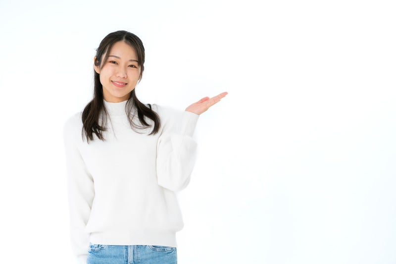 左手で案内する笑顔の女性