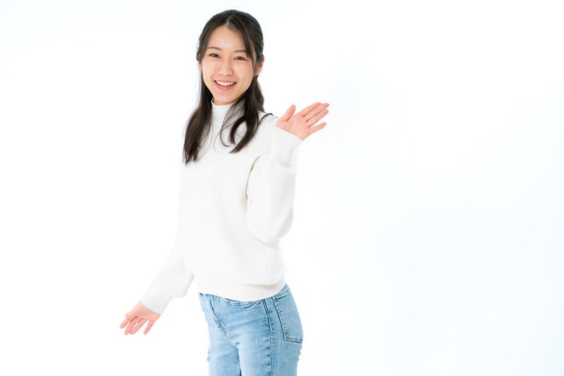 満面の笑みで手を挙げる女性の写真