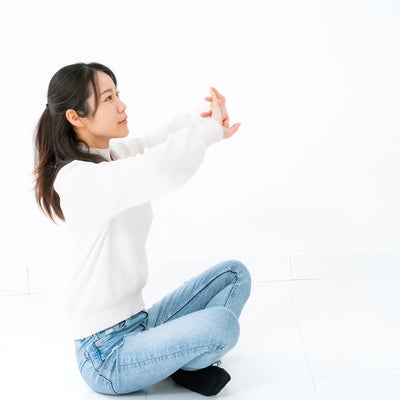 座ってストレッチする女性の写真