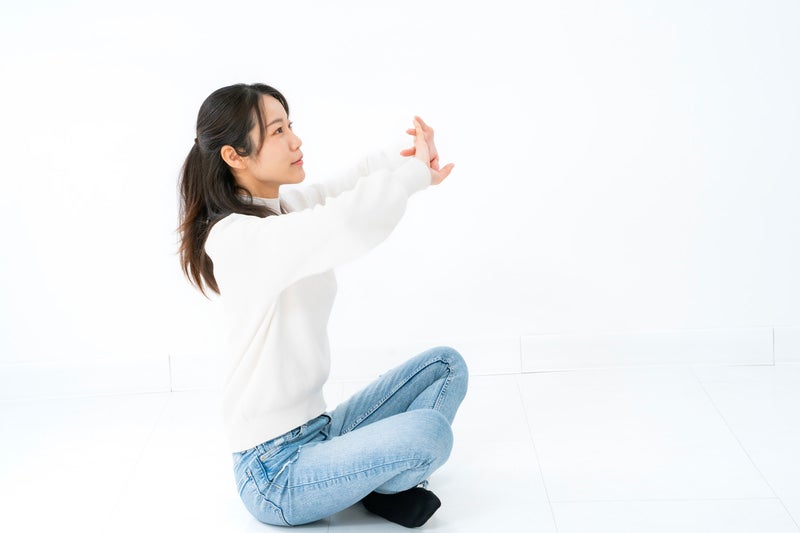座ってストレッチする女性の写真