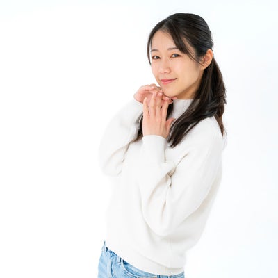顎先に伸びた指先と微笑む女性の素材