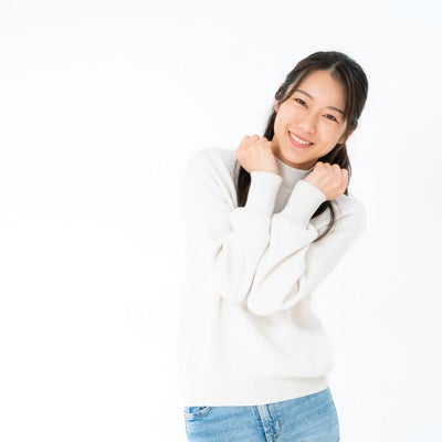 笑顔でぶりっ子ポーズの女性の写真