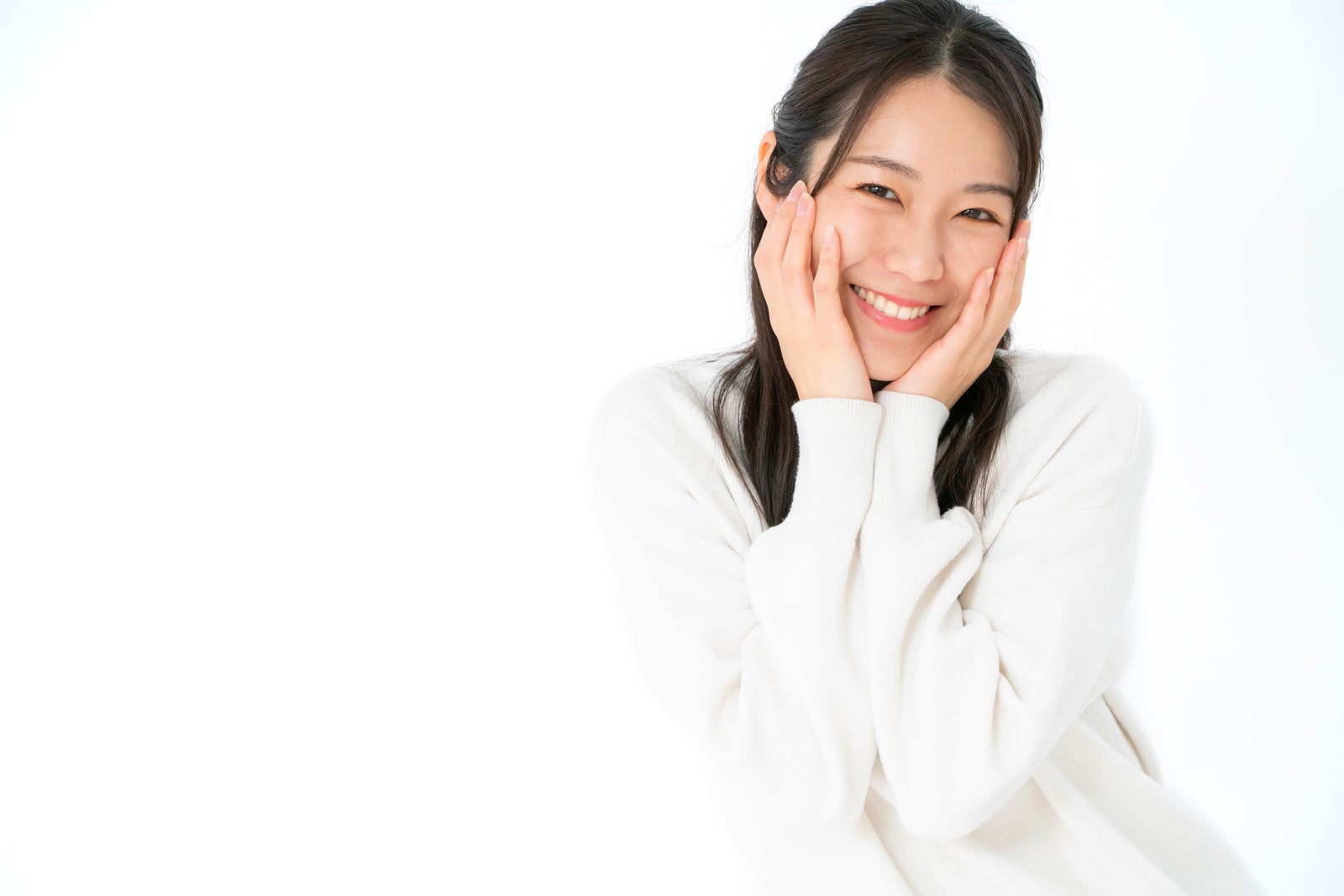 「満面の笑みの頬に手を添える女性」の写真［モデル：SAKI］