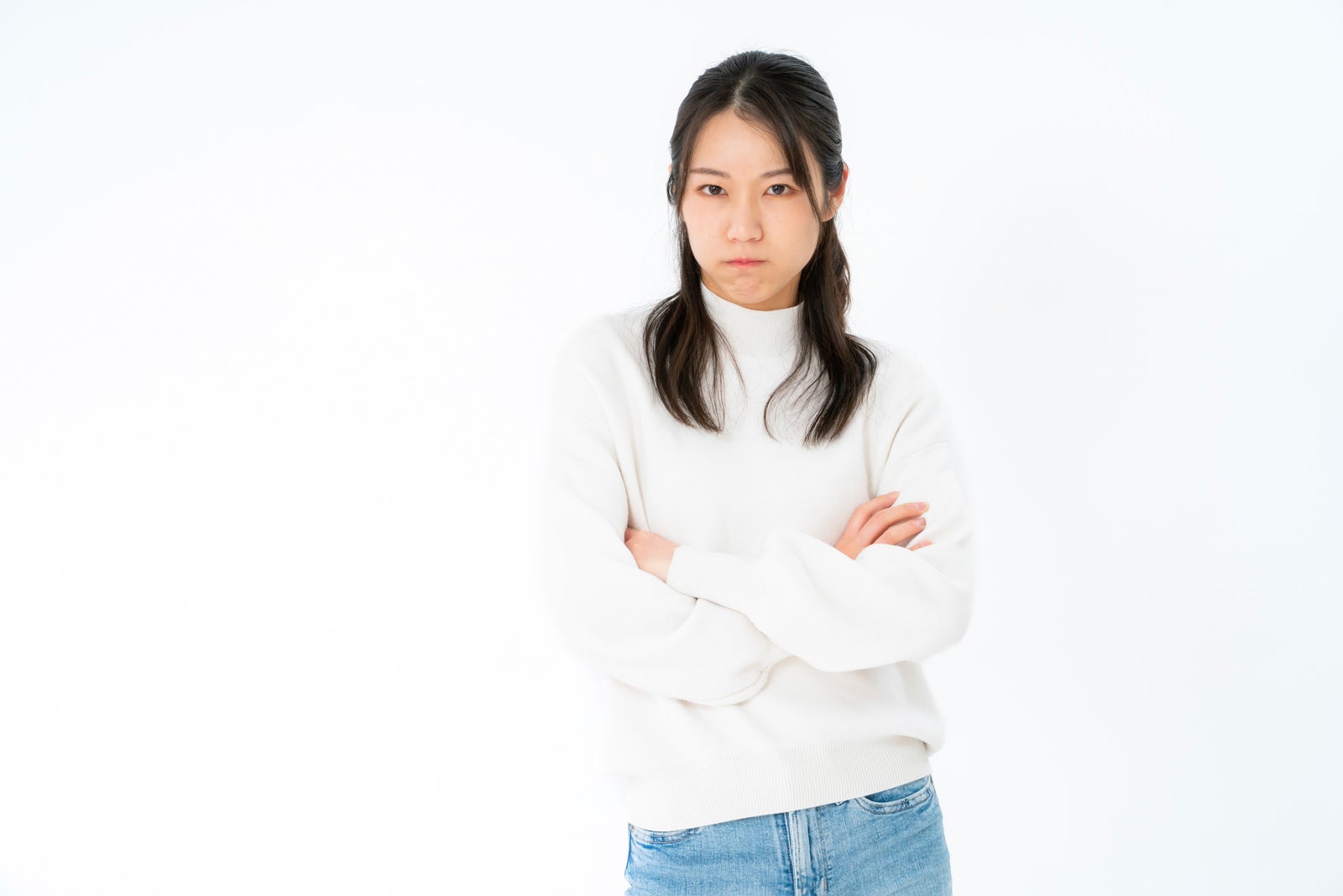 「不機嫌な表情で腕組みする女性」の写真［モデル：SAKI］