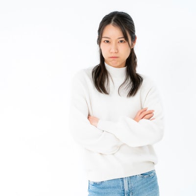 不機嫌な表情で腕組みする女性の素材