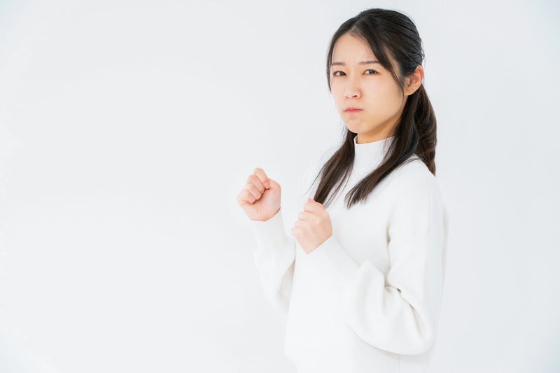 拳を握っていじける女性の写真