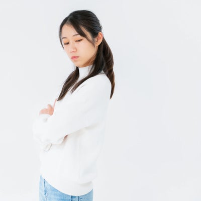 腕を組んで目をそらす女性の写真