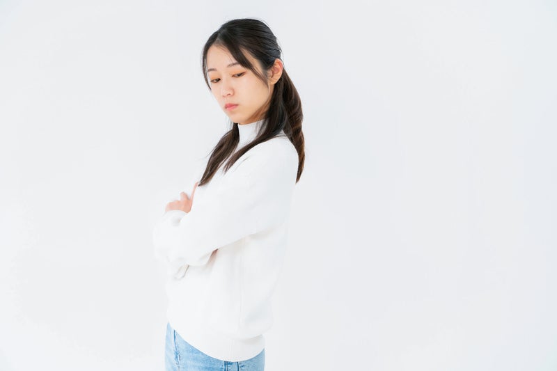 腕を組んで目をそらす女性の写真
