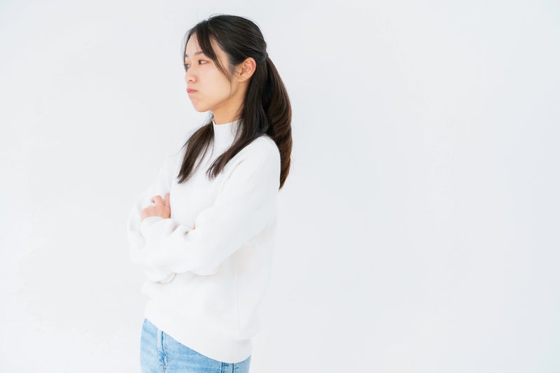 腕組みしてそっぽを向く女性の写真