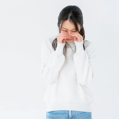 目を押えてめそめそする女性の写真