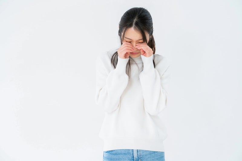目を押えてめそめそする女性の写真
