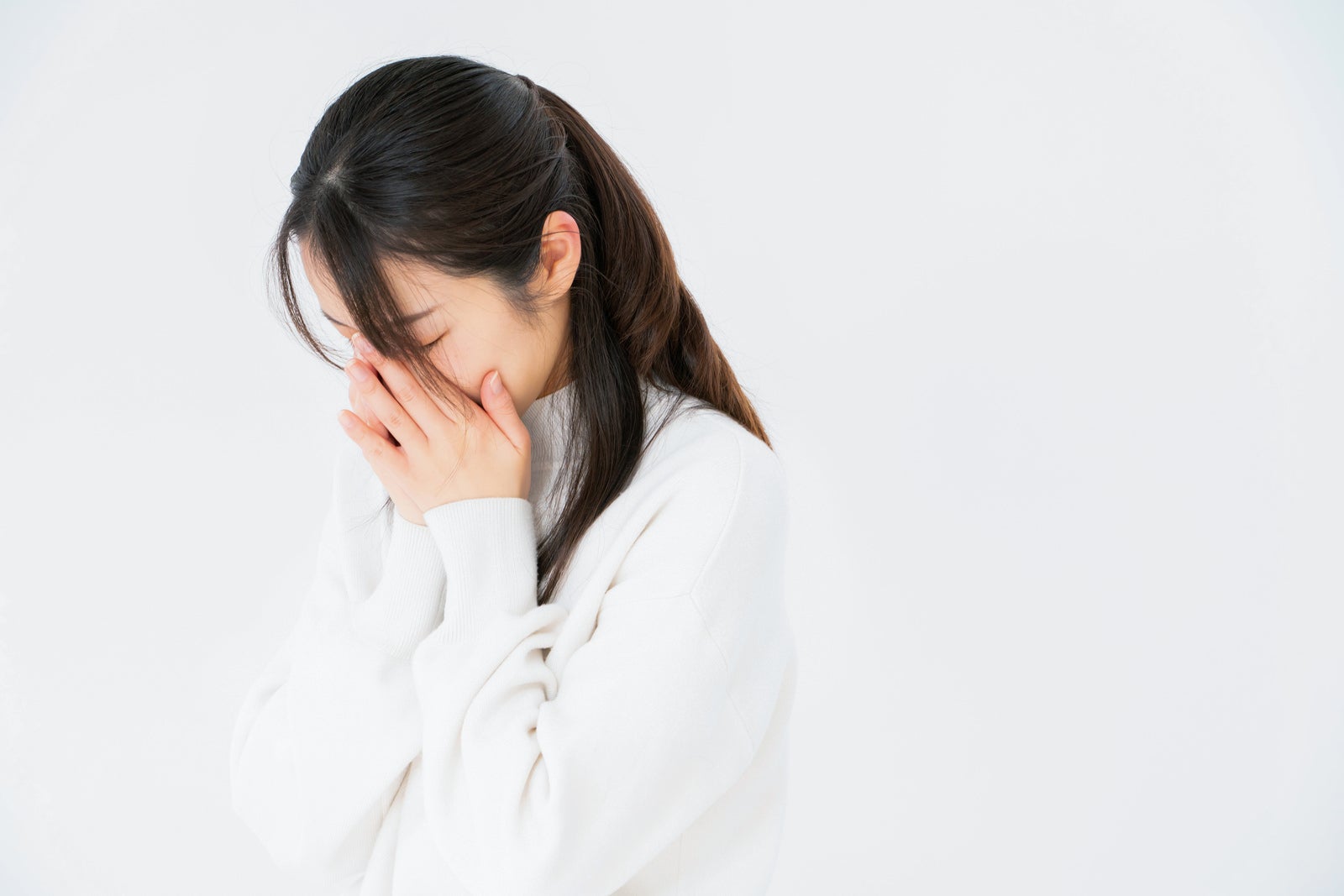 「顔を覆ってすすり泣く女性」の写真［モデル：SAKI］