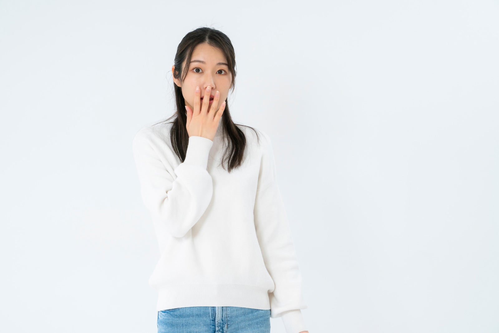 「ギョッとして口を押さえる女性」の写真［モデル：SAKI］