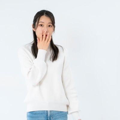 ギョッとして口を押さえる女性の写真