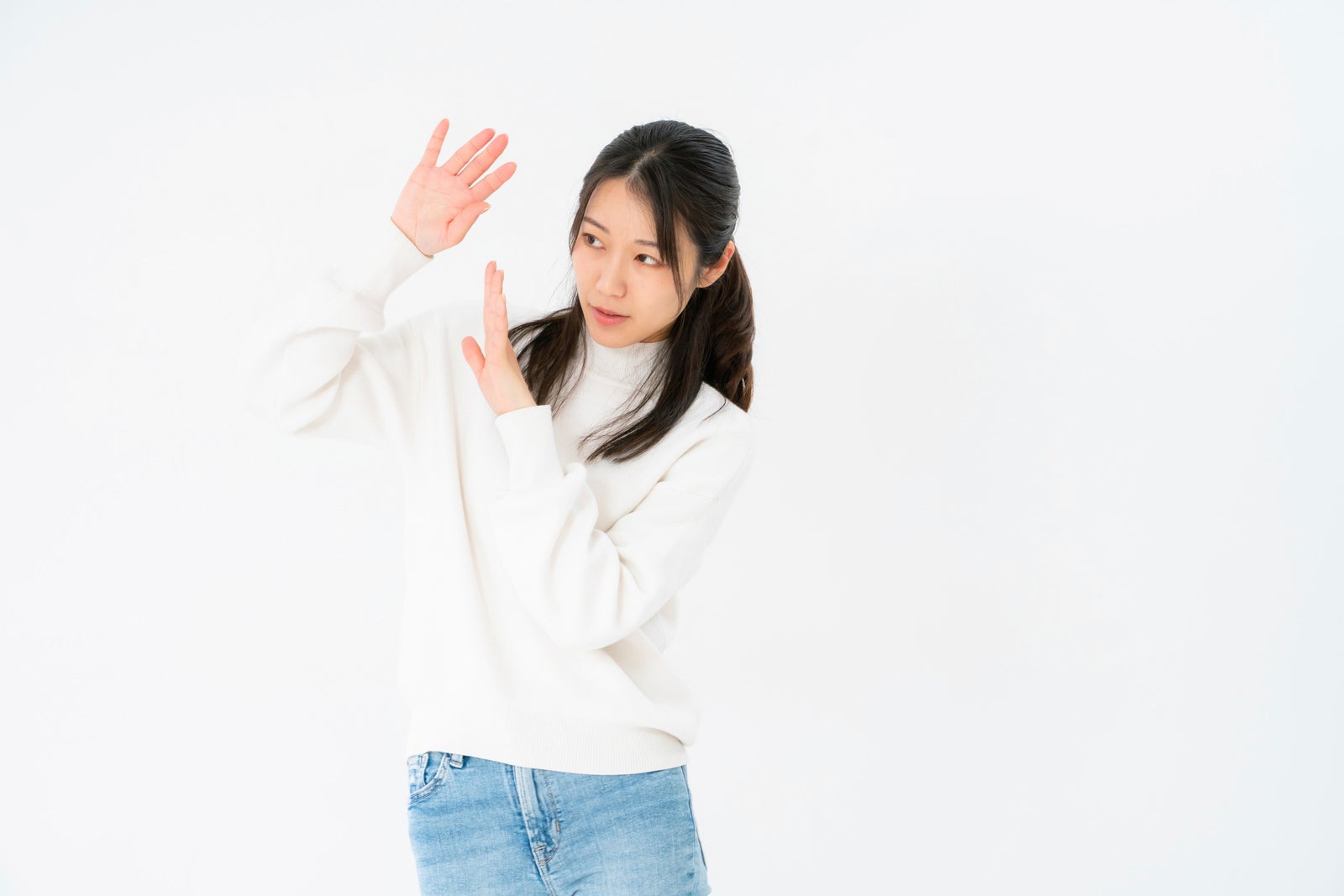 「両手で身を守る女性」の写真［モデル：SAKI］