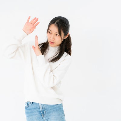 両手で身を守る女性の写真