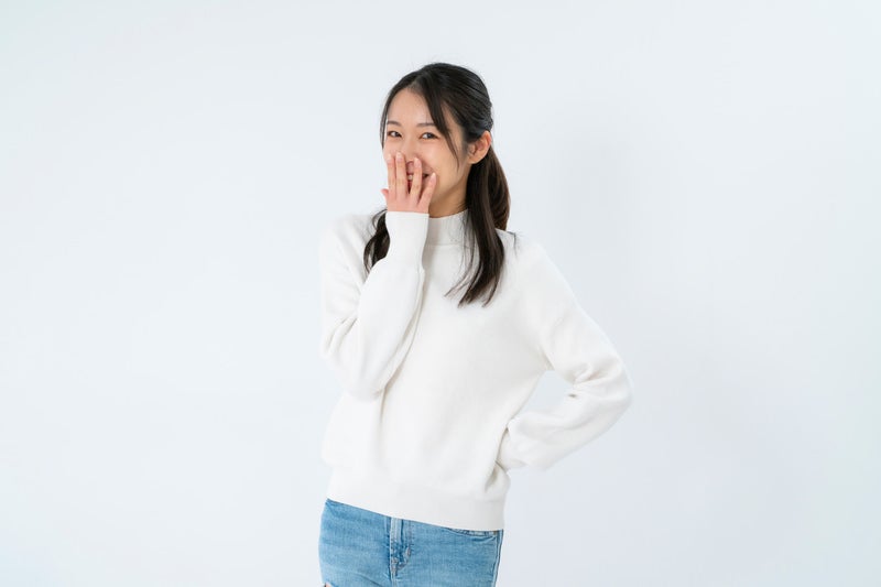 口を押えてクスクス笑いする女性の写真