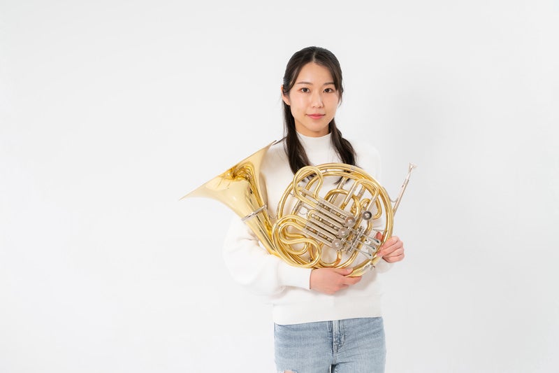 ホルンを手に持つ女性の写真