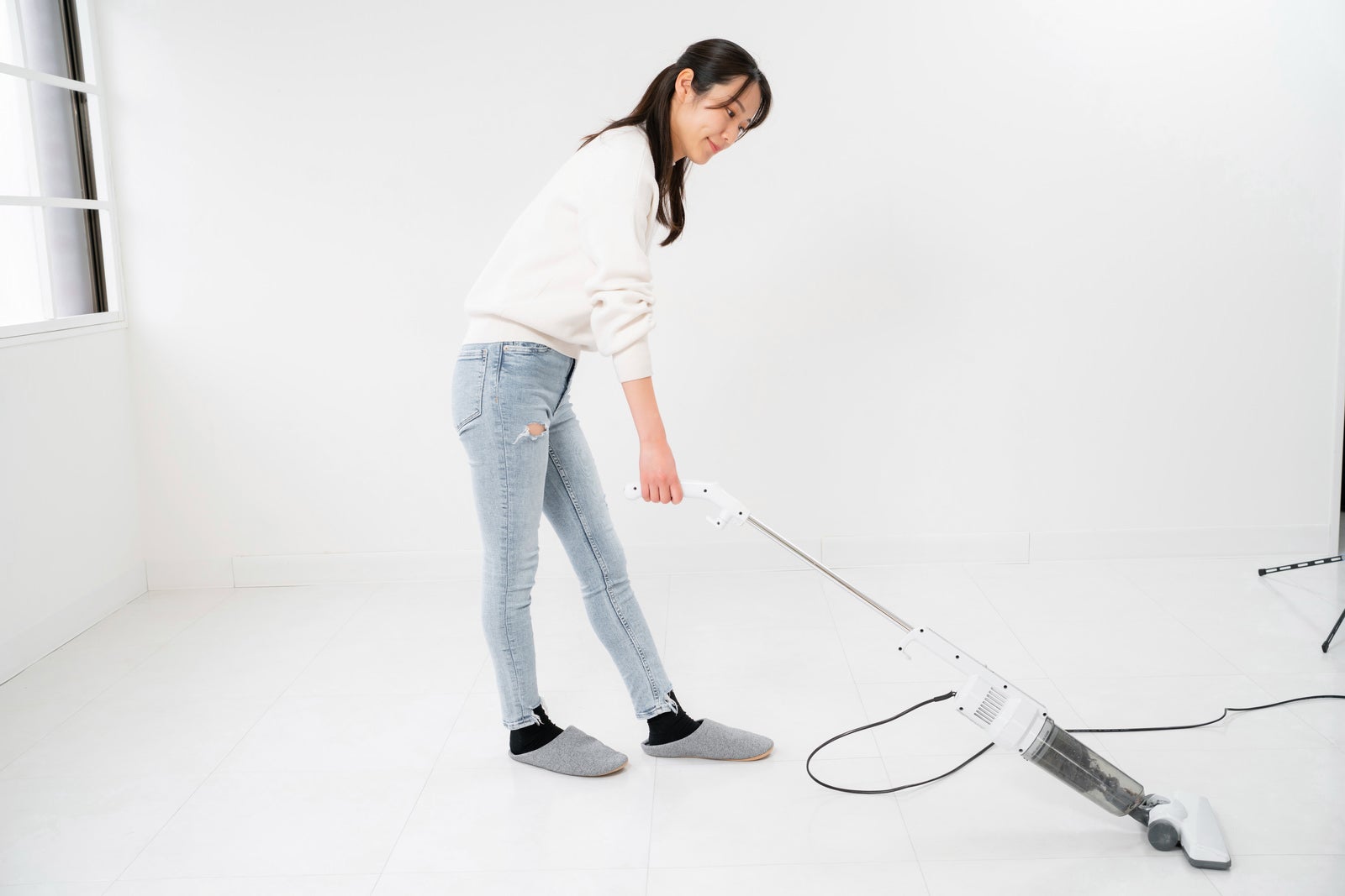 「掃除機を使う女性」の写真［モデル：SAKI］