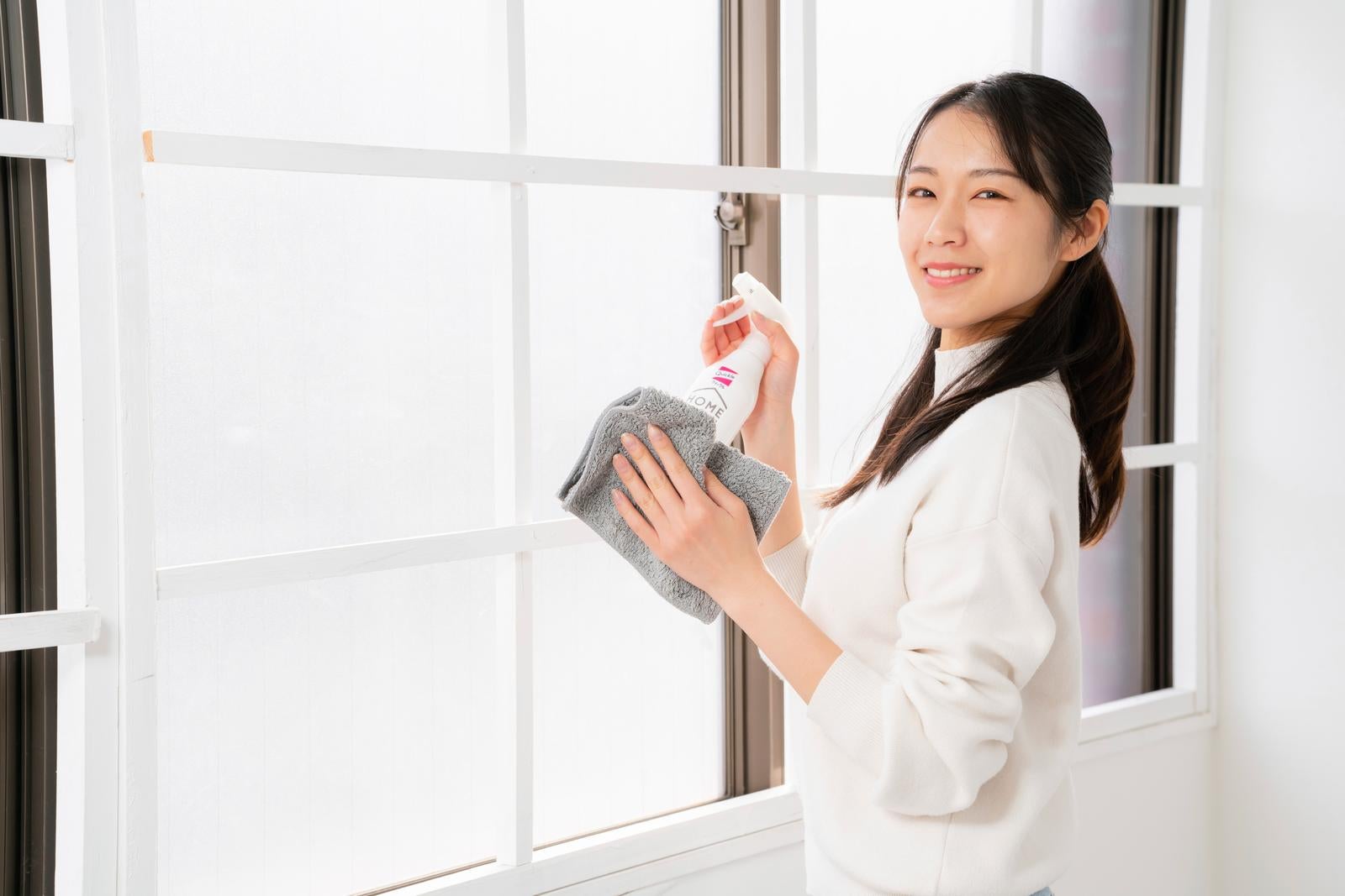 「暮れの大掃除で窓をキレイにする女性」の写真［モデル：SAKI］