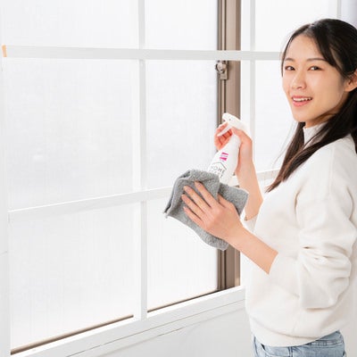 大掃除で窓を拭く女性の写真