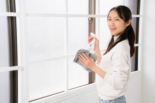 大掃除で窓を拭く女性の写真