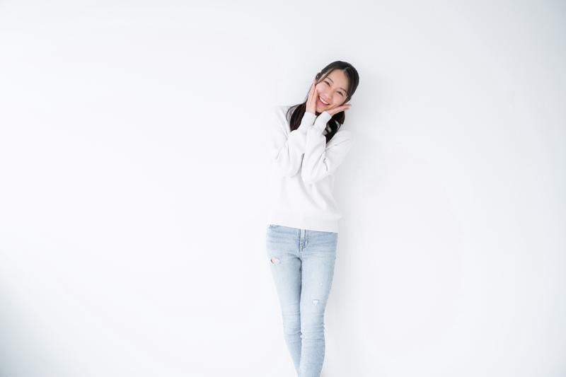 デニムパンツ姿で恥ずかしそうにする女性の写真