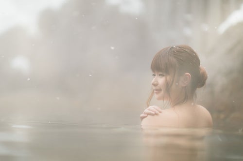 雪見露天風呂と入浴中の美女の写真