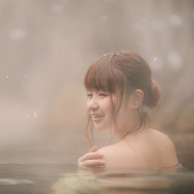 雪見露天風呂で満足そうに顔をほころばせる女性の写真