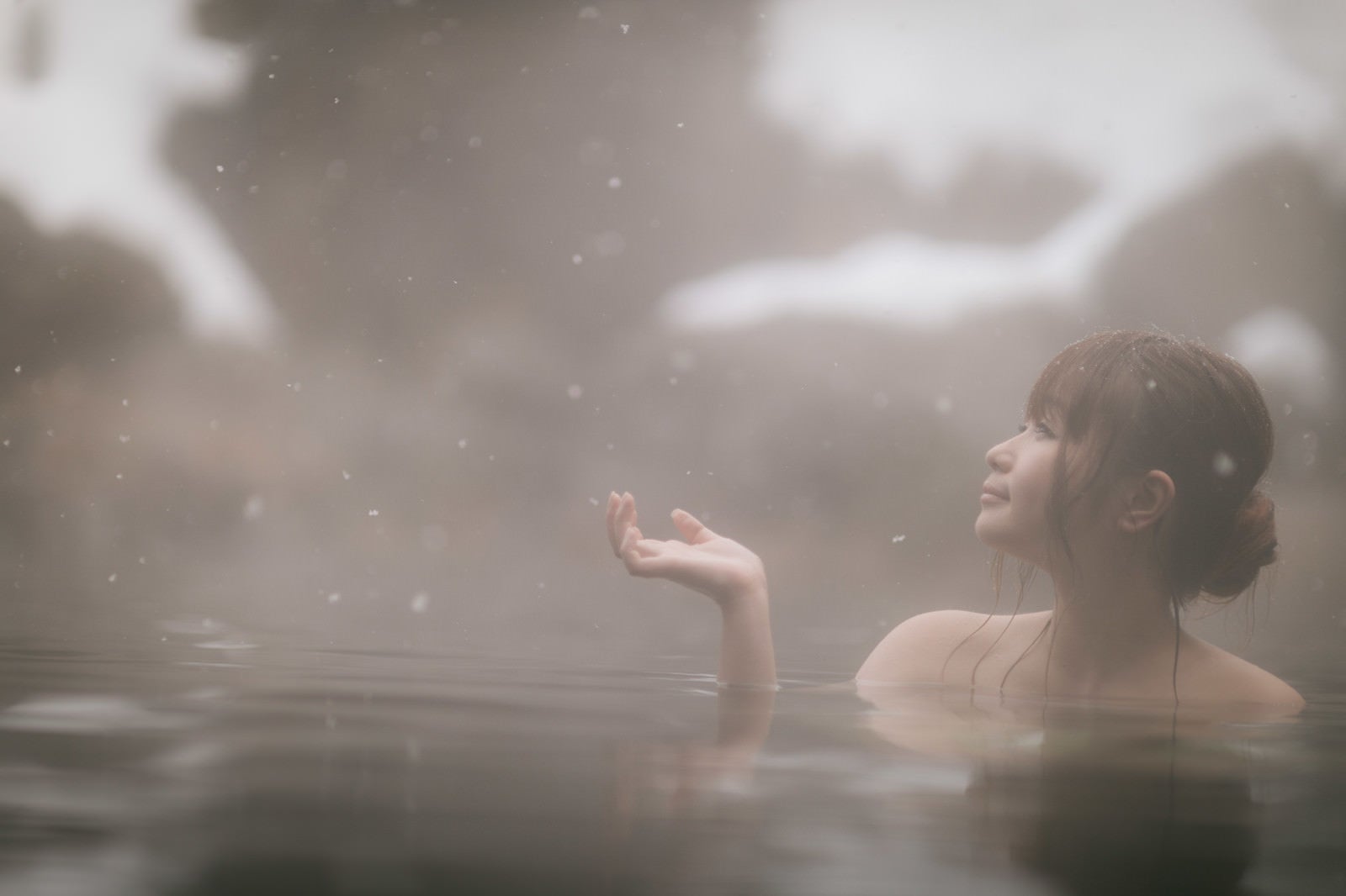 「粉雪舞う露天風呂に浸かる美女」の写真［モデル：茜さや］
