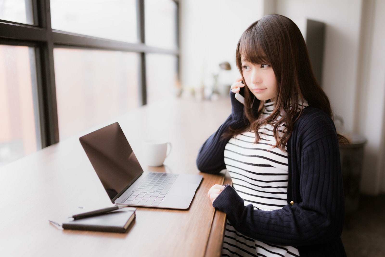 「クライアントへ確認の電話を入れるIT女子」の写真［モデル：茜さや］