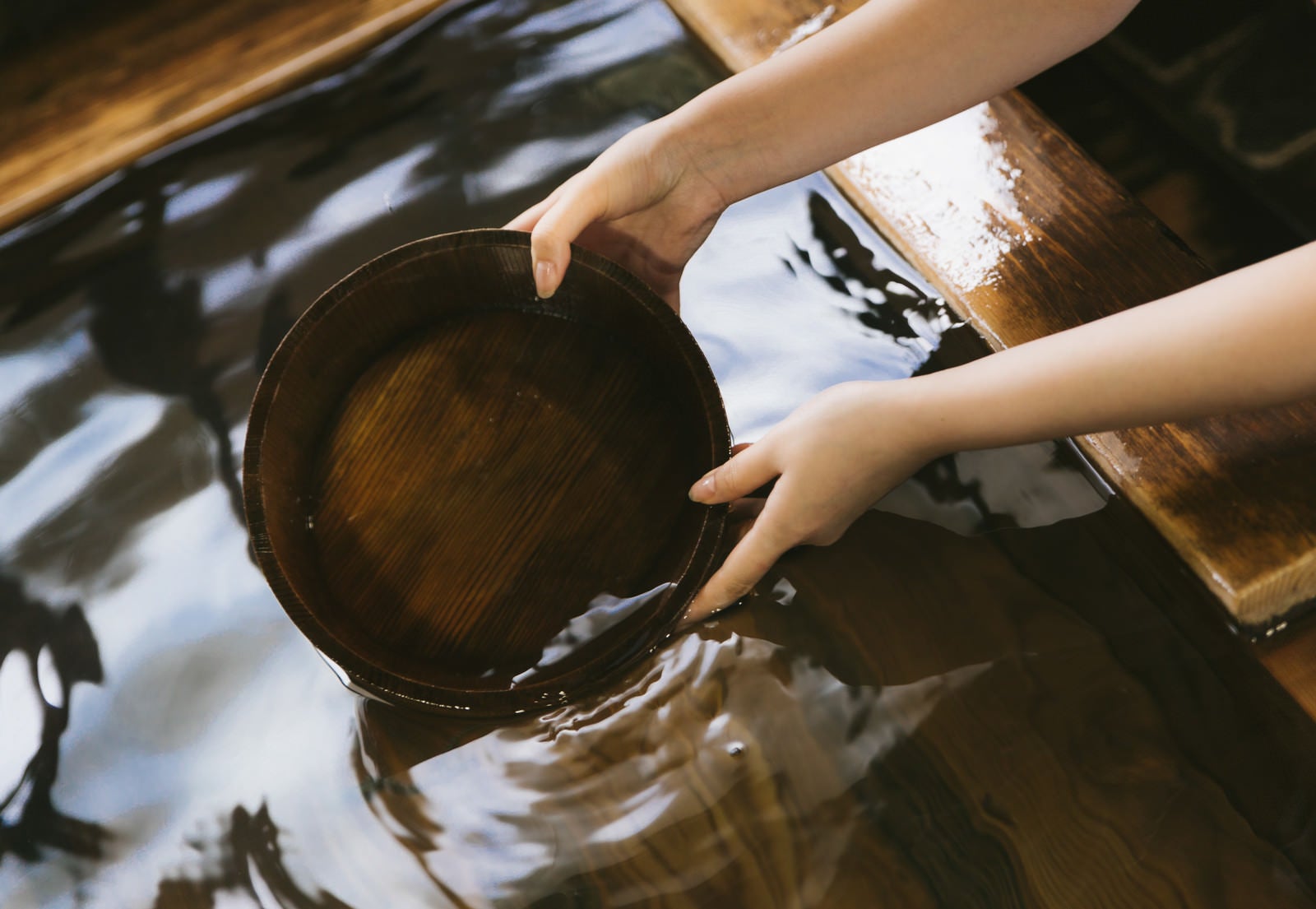 「湯船にかけ湯の桶を入れる」の写真