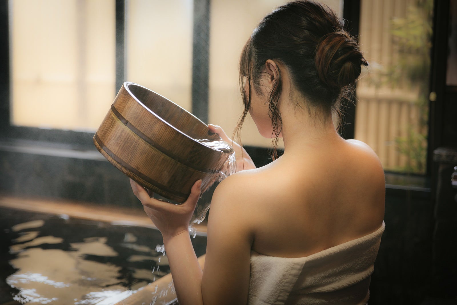 「肩にかけ湯をする女性の後姿」の写真［モデル：茜さや］