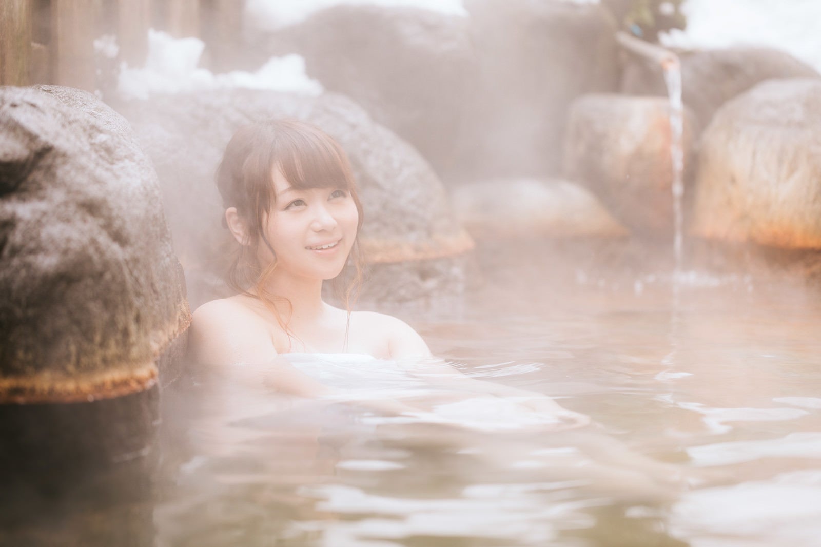 「源泉かけ流しの温泉を楽しむ湯けむり女子」の写真［モデル：茜さや］