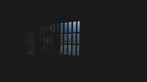 深夜、眠らない隣人の窓明かりの写真