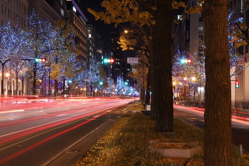 電飾で彩られた街並みと車の光跡の写真