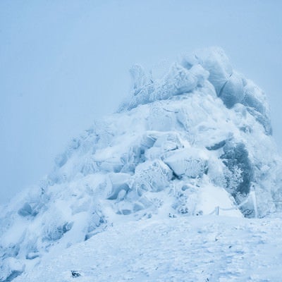 吹雪に耐える岩峰の写真