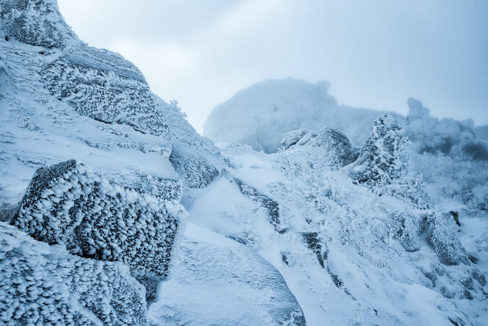 「立ち込めるガスで視界不良の雪山」の写真