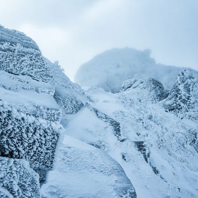 立ち込めるガスで視界不良の雪山の写真