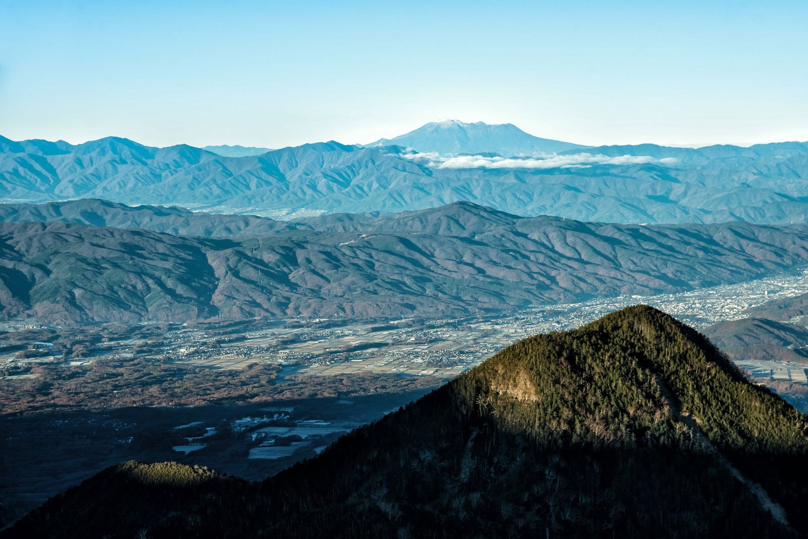 「麓の町並みと遥か遠くの御嶽山」の写真