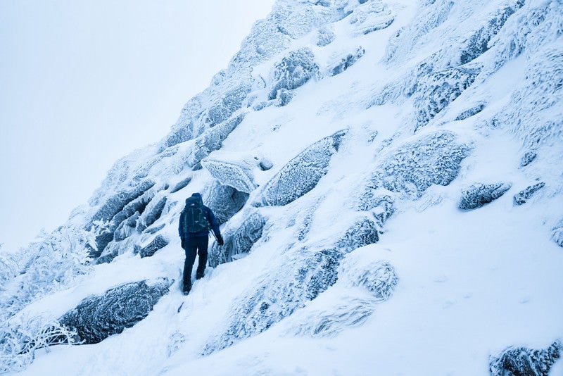 雪の斜面をトラバースする登山者の写真