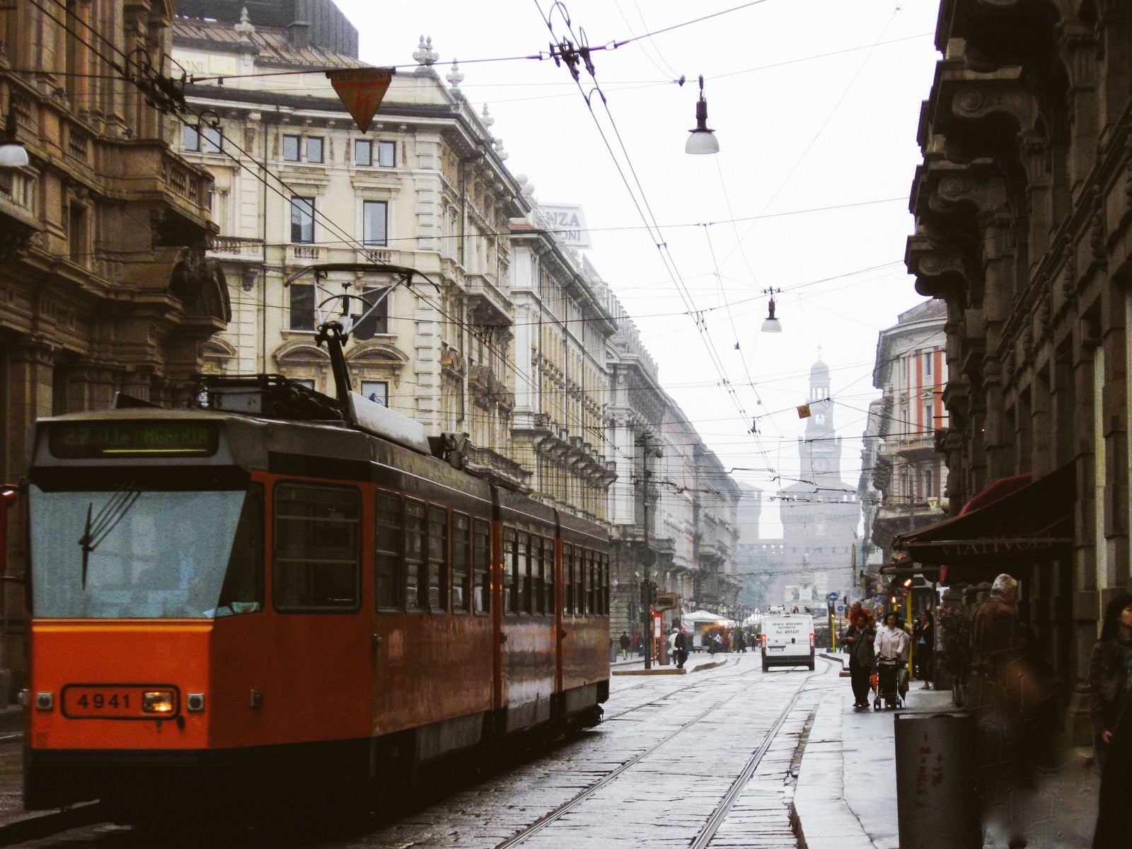 「ミラノの時計台へと続く路地を走る路面電車と街並み（イタリア）」の写真